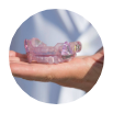 Hand holding light purple oral appliance