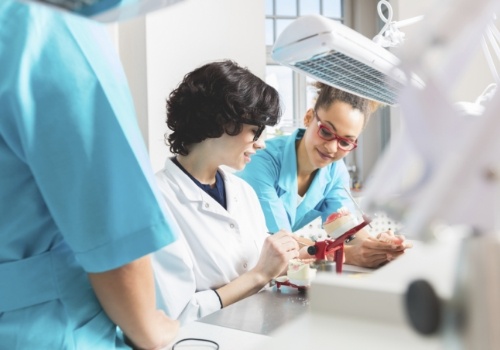 Three ceramists creating a dental restoration in a lab