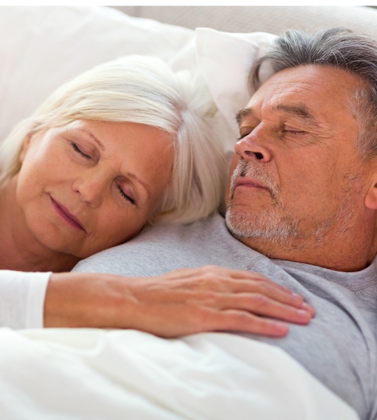 Senior man and woman sleeping soundly after treating obstructive sleep apnea in Glendale