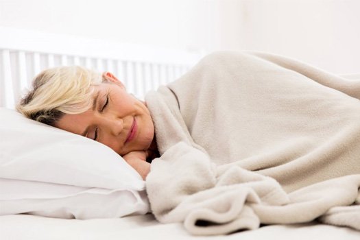 Oral Appliance Therapy: Woman sleeping peacefully with cozy blanket