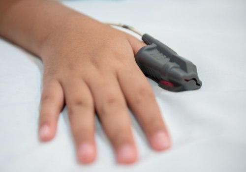 Person wearing fingertip pulse oximeter
