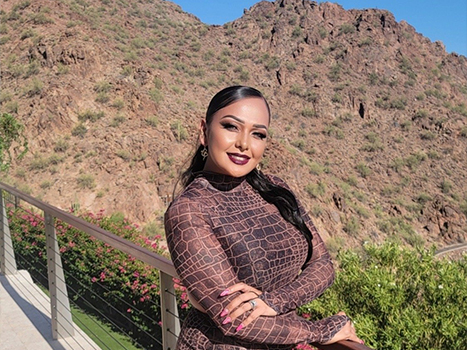 Cristy in brown dress with small mountain in background