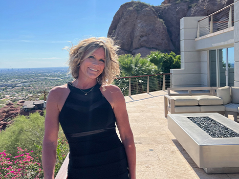 Tanya in black dress smiling on balcony