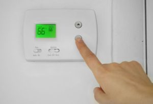 Person turning down their home’s thermostat